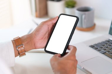 Çalışma yerinde oturan ve akıllı telefon kullanan genç bir adamın dikiz görüşü. Grafik görüntüleme kurgusu için boş ekran.
