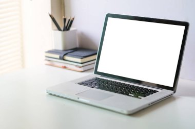 Modern workplace with laptop computer and cup of coffee on white table.	