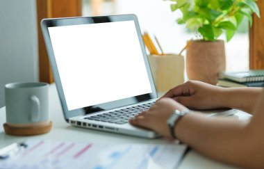 İş kadını elleri dizüstü bilgisayarın klavyesini daktilo ediyor..