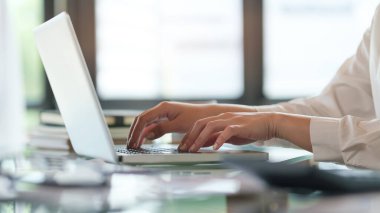 Close up view young woman freelancer hands typing on keyboard of laptop computer.	