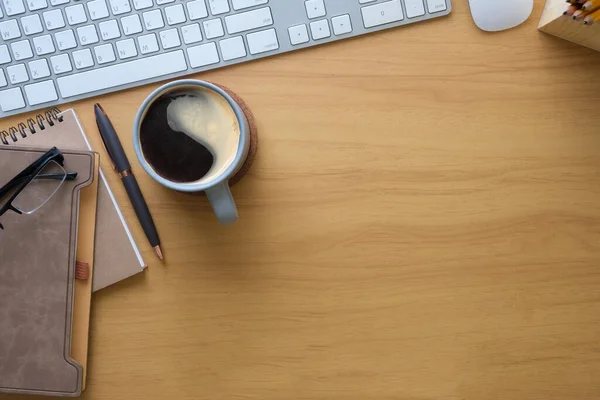 木制桌子上有一杯咖啡笔记本 眼镜和键盘 带有文本空间的顶部视图 — 图库照片