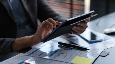 Dijital tablet üzerinde çalışan gülümseyen genç girişimcinin görüntüsü..