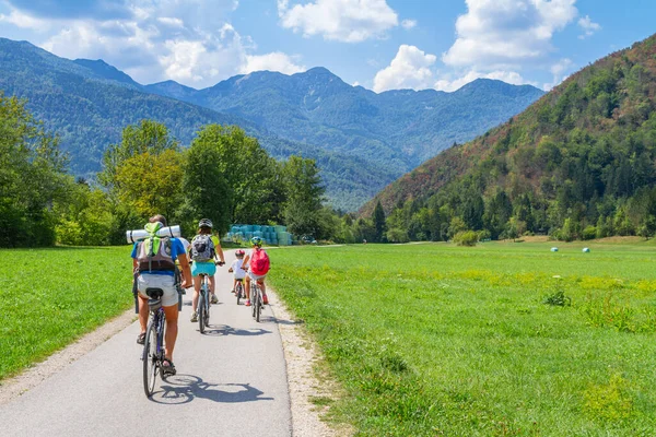 Bohinj, Slovenya - 19 Ağustos 2018: Güneşli bir yaz gününde Bohinj Vadisi 'nde bisikletle gezen bir aile.