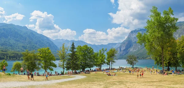 Slovenya 'nın Bohinj Gölü - 19 Ağustos 2018: Bohinj Gölü ve ana hamamının panoramik manzarası kısmen güneşli bir yaz gününde bir sürü insan