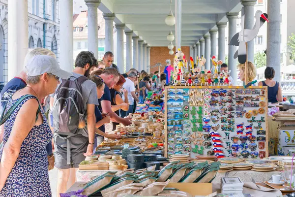 Ljubljana, Slovenya - 16 Ağustos 2018: Pek çok turist Ljubljanica Nehri kıyısındaki açık hava şehir pazarında hediyelik eşya almak için duruyor