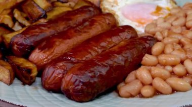 Geleneksel İngiliz kahvaltısı yumurta, sosis, fasulye, ızgara patates. Kapat..