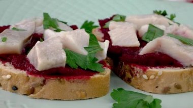 Haşlanmış pancar humusuyla diyet bruschetta ve maydanozlu tuzlanmış ringa balığı yavaşça döner. Organik yiyecekler. Vejetaryen İskandinav mutfağı. Kapat..