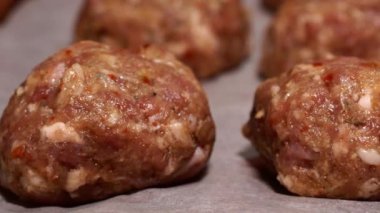 Fresh raw uncooked beef, lamb, pork meatballs in a row on table. Semi-finished of raw meat on ready for preparation. Food background. Close up.