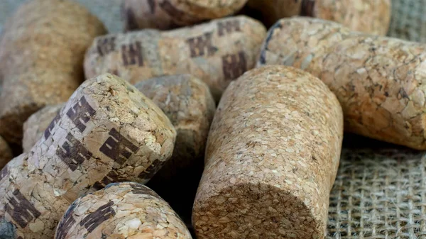Different champagne or wine corks on from wine bottles on burlap fabric an be used as background. Selective focus. Close up.
