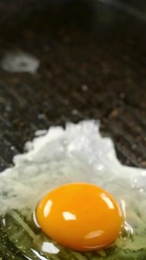 Kızarmış yumurta ya da ızgara tavada kızgın yağda kızartılmış omlet ve yapışmaz kaplama. Ev mutfağında hazır vejetaryen yemekleri. Ağır çekim. Dikey. Yakın plan..