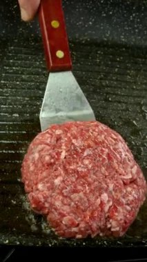 Burger pirzolası ve ızgara tavada kızarmış kırmızı soğan. Ev mutfağında hazır ve besleyici yemekler var. Dikey. Kapat..