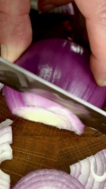生の新鮮な紫の赤玉ねぎは まな板上のナイフでスライスにカット 家庭用キッチンでおいしいベジタリアンやビーガンフードを準備します 閉じろ — ストック動画
