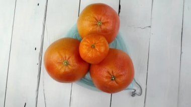 Üç olgun sulu greyfurt çevre dostu ızgarada beyaz arka planda dönüyor. Turunçgil taze meyve sağlıklı vejetaryen ve vejetaryen yemeği. Kapat..