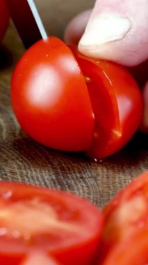 Keskin bıçak, içerideki dokuları gösteren olgun domatesleri incelikle dilimliyor. Yemek blogcuları, yemek pişirme dersleri ve yemekle ilgili her şey için. Dikey.