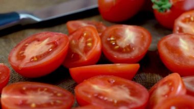 Mutfak bıçağı ve tahta kesme tahtasının üzerinde taze kırmızı kiraz domatesleri. Gıda blogcuları ve içerik yaratıcıları için. Dolly vurdu. Kapat..