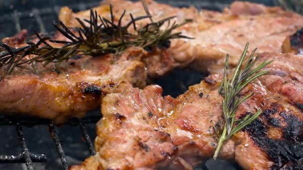 ローズマリーの小枝と豊かな豚肉のステーキ ホット石炭の完璧へのグリル 屋外バーベキューのホットグレートに口の中で豚肉のステーキ散水 閉じろ — ストック動画
