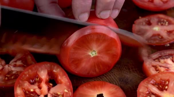 キッチンナイフでトマトの薄切りを切り刻むシェフの手のアクション ジューシーなトマトサラダビーガンまたはベジタリアン料理の準備 閉じろ — ストック動画