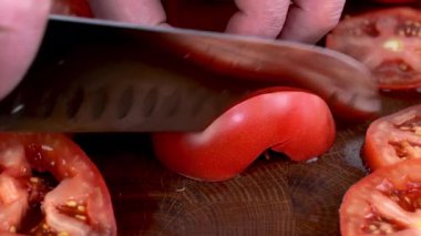 Mutfak bıçağıyla ince dilimlenmiş domates doğrayan şeflerin işi. Sulu domates salatası vejetaryen ya da vejetaryen yemeği. Kapat..