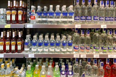 Kyiv, Ukrayna, Haziran 2023: - Süpermarkette raflarda raflara dizilmiş farklı cam votka şişeleri. Alışveriş rafında güçlü alkollü içecekler. Seçici odaklanma. Kapat..