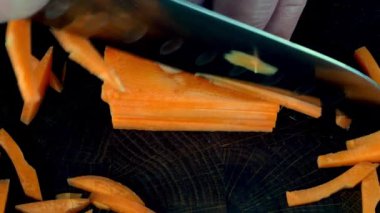 Bıçakla kesilmiş canlı turuncu taze çiğ havuç çizgili vor cooling. Ev mutfağında vejetaryen ve vejetaryen yemekleri var. Kapat..