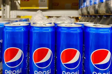 Kyiv, Ukrayna 28.07.2023: Pepsi, süpermarkette satılık olarak sergilenen teneke kutuda içiyor. Alışveriş merkezinin bakkal bölümünde içeceklerle raflar. Kapat..