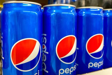 Kyiv, Ukrayna 28.07.2023: Pepsi, süpermarkette satılık olarak sergilenen teneke kutuda içiyor. Alışveriş merkezinin bakkal bölümünde içeceklerle raflar. Kapat..