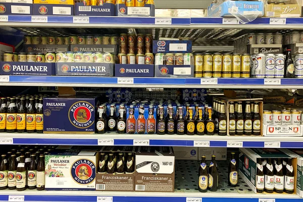 Kyiv, Ukrayna 28.07.2023: - Paulaner bira markası süpermarkette raflara istiflenmiş. Alkol departmanında bir sürü bira kutusu açtım..