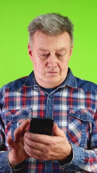 男人在智能手机里看消息会抓头 什么都不懂 惊讶地看着电话的人不懂留言 耸了耸肩 绿色屏幕 垂直方向 — 图库视频影像