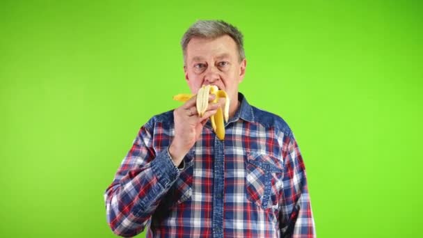 Starší Muž Jíst Zdravé Čerstvé Žluté Banány Při Pohledu Kamery — Stock video