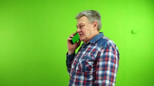 携帯電話で話し おかしな冗談でヒステリックに笑う年配の男性 スマートフォンとの楽しい会話をする成熟した人 グリーンスクリーン クロマキー — ストック動画