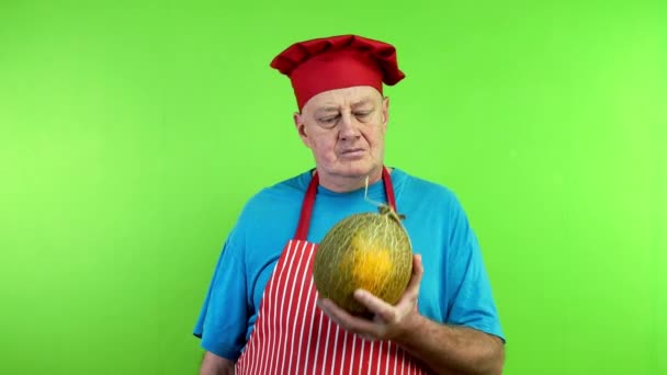 老厨师穿着围裙闻成熟的甜瓜 做了个好吃的 完美的手势 成熟的甜瓜 厨师宣传素食主义或素食主义 绿色屏幕 — 图库视频影像