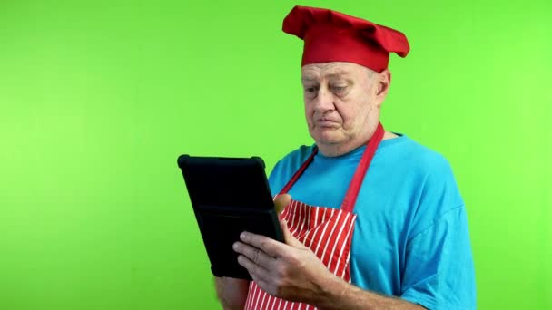 Старший Кухар Фартусі Читає Рецепт Планшеті Нічого Розуміючи Зрілий Шеф — стокове відео