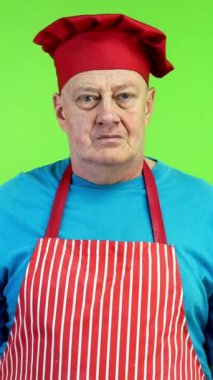 Restoranın sahibi ya da aşçısı kollarını kavuşturup kameraya gülümsedi. Başarılı şef gülümsüyor ve yaptığı işten memnun. Yeşil ekran, krom anahtar. Dikey.