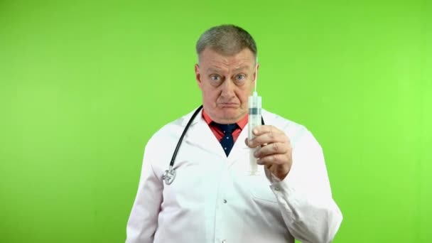 资深愤怒的医生威胁他的食指和大注射器 成熟的医生对不良行为感到失望 并承诺要惩罚 绿色屏幕 — 图库视频影像