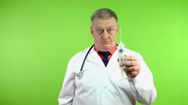 Starszy Wściekły Lekarz Grozi Zaciśnięciem Pięści Dużą Strzykawką Dojrzały Medyk — Wideo stockowe