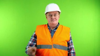 Sıkı şapkalı, gülümseyen ve kollarını kavuşturan kendinden emin kıdemli bir inşaatçı. Kasklı, mutlu ve gururlu bir işçi. Yeşil ekran. Krom anahtar.