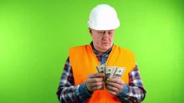Tatminsiz inşaatçı iş için para sayar ve daha fazlasını ister. Kıdemli müteahhit işinden memnun değil ve daha yüksek ücret talep ediyor. Yeşil ekran. Krom anahtar.