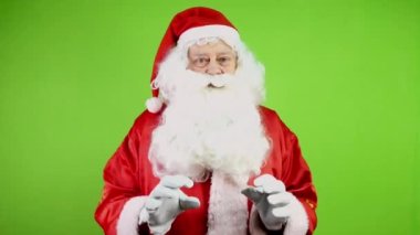 Neşeli Noel Baba elleriyle el kol hareketi yapıyor ve Noel 'i kutluyor. Neşeli Noel Baba Noel 'in gelişinde neşeli duyurular yapar. Yeşil ekran. Krom Anahtar.