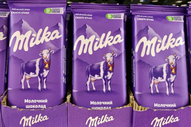 4 Ekim 2023 'te Milka İsviçreli şirketten alınmış sütlü çikolata süpermarkette satışa sunuldu. Büyük marketin bakkal bölümünde şeker satıyorum. Seçici odaklanma. Yumuşak odak.