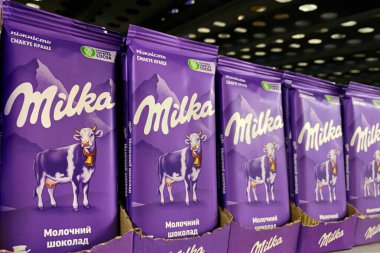 4 Ekim 2023 'te Milka İsviçreli şirketten alınmış sütlü çikolata süpermarkette satışa sunuldu. Büyük marketin bakkal bölümünde şeker satıyorum. Seçici odaklanma. Yumuşak odak.