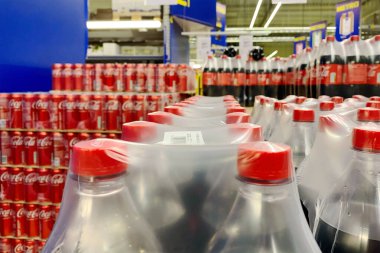 4 Ekim 2023, Coca Cola plastik film ve konservelere doldurulmuş plastik şişelerle büyük mağazada satılmaya hazırdı. Coca Cola karbonatlı meşrubattır. Seçici odaklanma. Yumuşak odak.