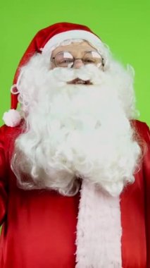 Neşeli Noel Baba elleriyle el kol hareketi yapıyor ve Noel 'i kutluyor. Neşeli Noel Baba Noel 'in gelişinde neşeli duyurular yapar. Yeşil ekran. Krom Anahtar. Dikey.