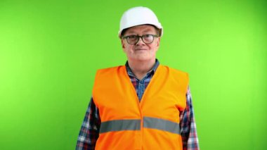 Sıkı şapkalı, gülümseyen ve kollarını kavuşturan kendinden emin kıdemli bir inşaatçı. Kasklı, mutlu ve gururlu bir işçi. Yeşil ekran. Krom anahtar.