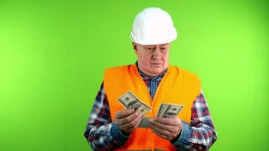 Tatminsiz inşaatçı iş için para sayar ve daha fazlasını ister. Kıdemli müteahhit işinden memnun değil ve daha yüksek ücret talep ediyor. Yeşil ekran. Krom anahtar.