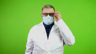 Baş doktor baş ağrısını veya migreni hafifletmek için şakaklara dokunup ovuyor. Aşırı yüklenmiş yetişkin doktor baş ağrısı çekiyor ve sağlık sorunuyla başa çıkmaya çalışıyor. Yeşil ekran, krom anahtar.