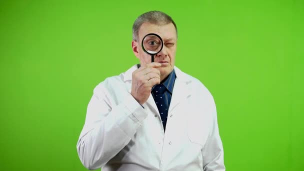 Senior Doctor Holding Magnifying Glass Looking Forward Have Surprised Face — Stock Video