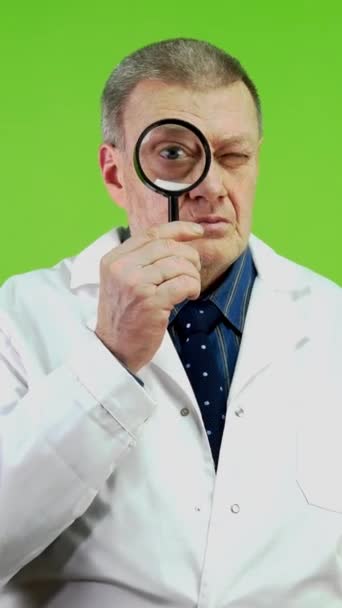Senior Läkare Håller Förstoringsglas Ser Framåt Och Har Överraskat Ansikte — Stockvideo