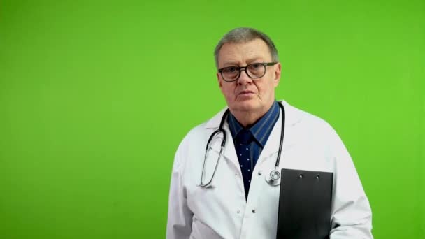 身穿白衣 面带微笑的老医生手里拿着文件夹走着 成熟的医生精力充沛地去见病人或看病人 绿色屏幕 — 图库视频影像