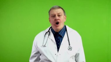 Mutsuz doktor umutsuzca haykırıyor ve kaybına inanamıyor. Bozuk bir yetişkin doktor, bir şeyini ya da sevdiği birini kaybettiği için duygusal çöküntü yaşıyor. Yeşil ekran. Krom anahtar.
