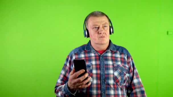 Rolig Glad Senior Man Går Hörlurar Med Smartphone Händerna Obekymmerslös — Stockvideo